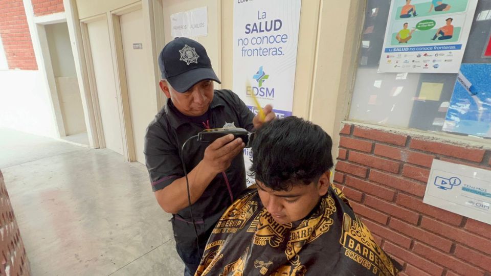 Policías de Santa Catarina brindan cortes de cabello gratuitos a migrantes en Casa Monarca.