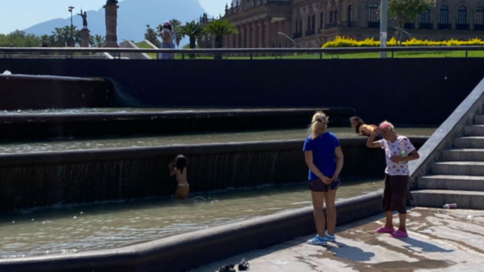 Madre de familia lleva a sus hijos a refrescarse a una de las fuentes de la Macroplaza.