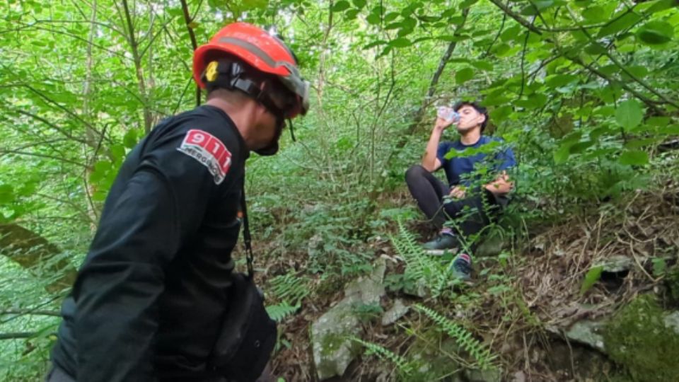 Elemento de Protección Civil con el joven extraviado.
