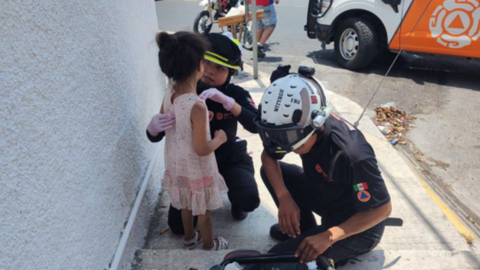 Elementos de Protección Civil atendiendo a niña.