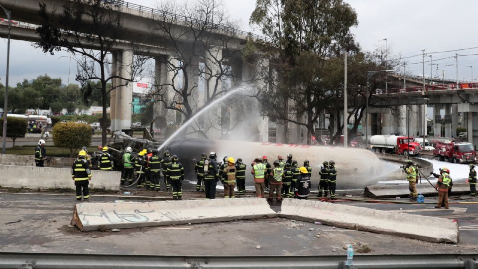 Integrantes del Cuerpo de Bomberos controlan un incendio luego del accidente de un camión de gas este miércoles, en Ciudad de México (México).