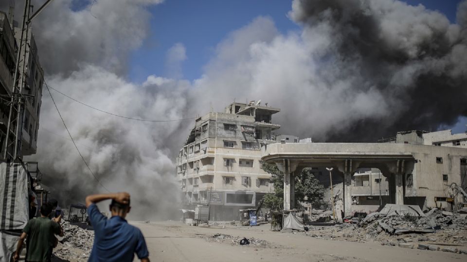 Palestinos se cubren durante un ataque aéreo israelí en medio de una operación militar en la Ciudad de Gaza, Franja de Gaza, 27 de septiembre de 2025.