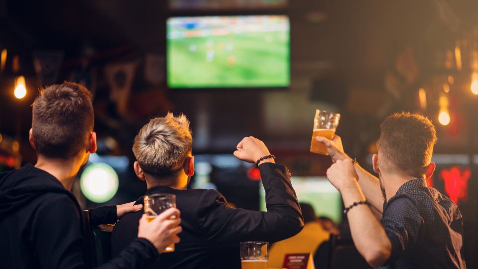 Grupo de amigos viendo el futbol en un pub