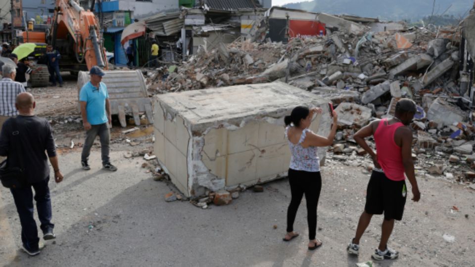 Personas observan este miércoles un edificio destruido por el terremoto de magnitud 7.4 en Dosquebradas Risaralda, Colombia.